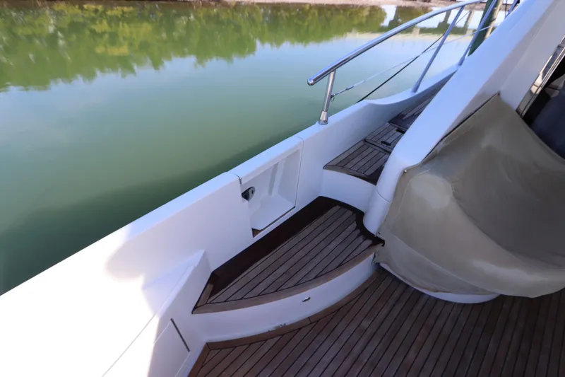 Slide: The Image of 2007 Azimut 62S yacht deck with wooden steps and railing by calm water. - 19