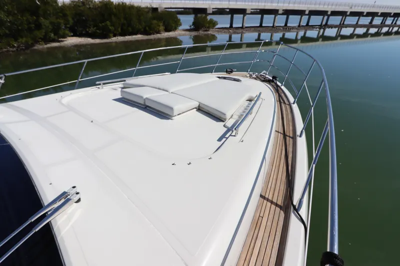 Slide: The Image of 2007 Azimut 62S yacht deck with sun loungers, sleek design, calm water backdrop. - 21