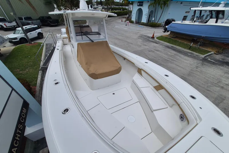 Slide: The Image of Regulator 35 boat 2026, white deck, brown cover, dockside view. - 14