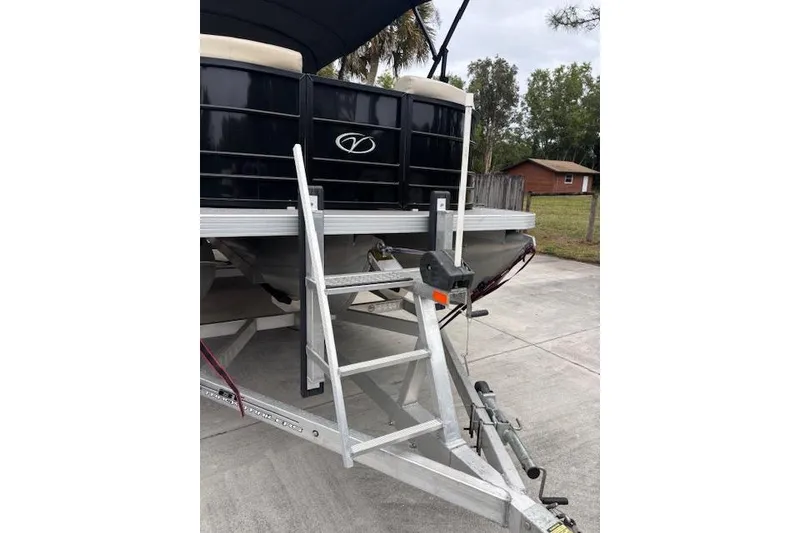 Slide: The Image of 2022 Veranda Vista 22RC pontoon boat on trailer with ladder, parked outdoors. - 11