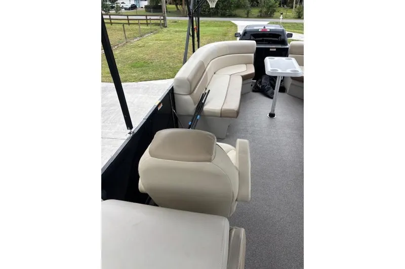 Slide: The Image of 2022 Veranda Vista 22RC pontoon boat interior with beige seating and table. - 22