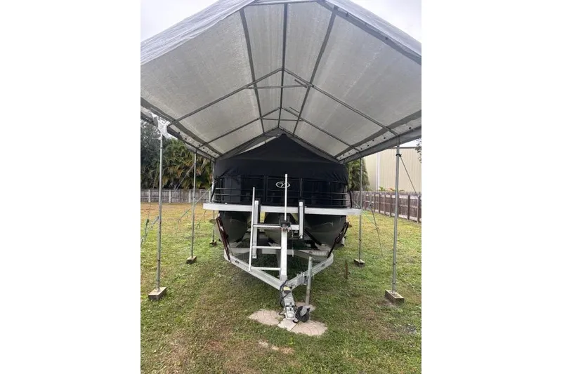 Slide: The Image of 2022 Veranda Vista 22RC boat under a metal canopy on grass. - 26