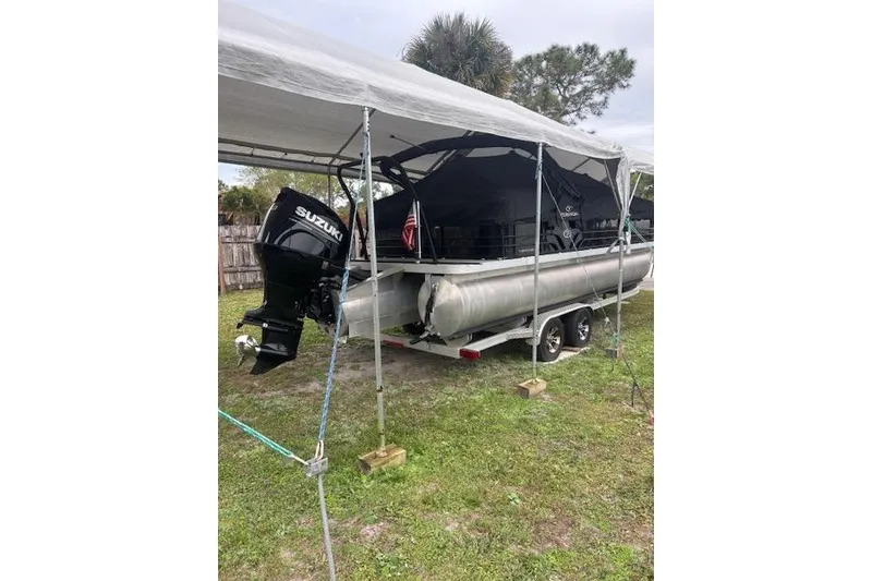 Slide: The Image of 2022 Veranda Vista 22RC pontoon boat with Suzuki outboard motor under a canopy. - 29