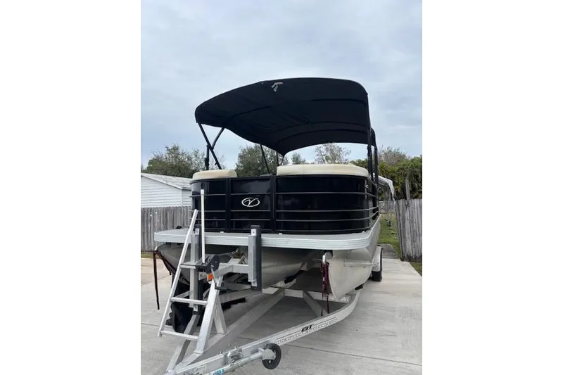 Slide: The Image of 2022 Veranda Vista 22RC pontoon boat on trailer with canopy, parked outdoors. - 3
