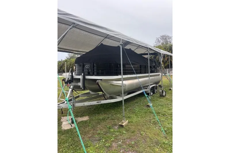 Slide: The Image of 2022 Veranda Vista 22RC pontoon boat under canopy on trailer. - 33