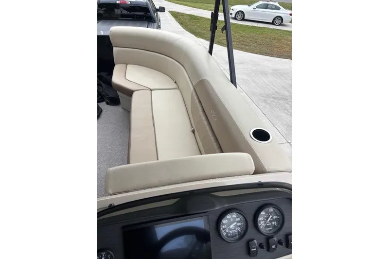 Slide: The Image of 2022 Veranda Vista 22RC boat interior with beige seating and dashboard gauges. - 9