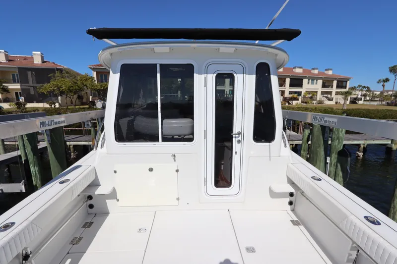 Slide: The Image of 2008 Glacier Bay 3080 Coastal Runner boat docked at marina, featuring spacious deck. - 14