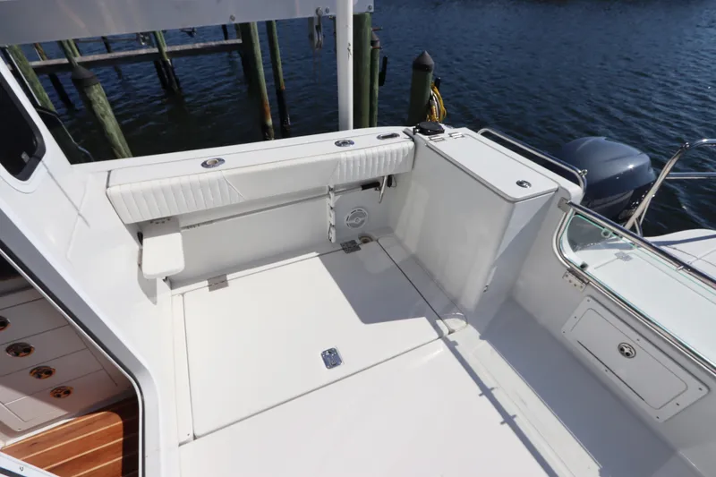 Slide: The Image of 2008 Glacier Bay 3080 Coastal Runner boat interior with seating and storage, docked by water. - 15