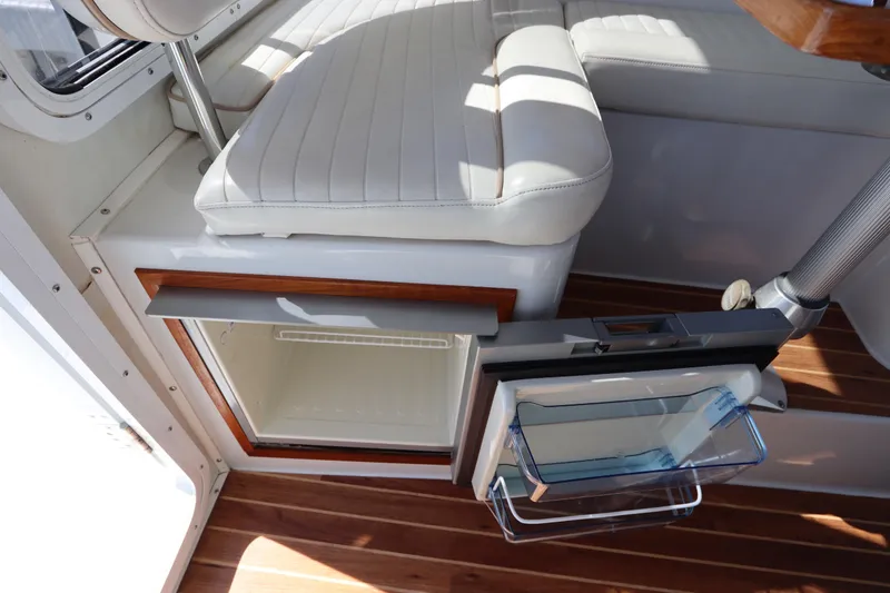 Slide: The Image of 2008 Glacier Bay 3080 Coastal Runner interior with open fridge and cushioned seating. - 33