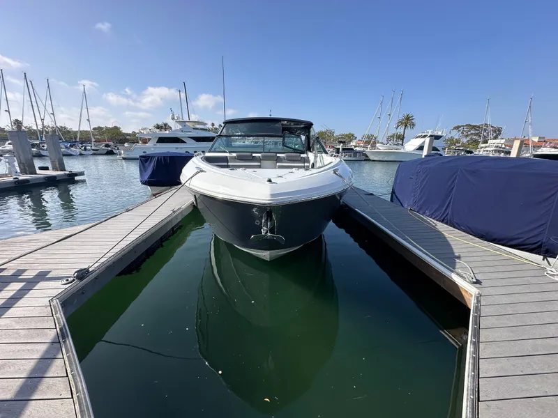 Slide: The Image of A 2021 Cruisers Yachts 38 GLS docked in a marina, surrounded by other boats. - 20