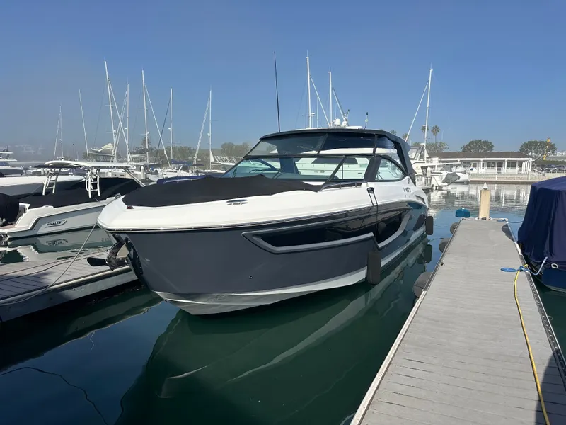 Slide: The Image of A 2021 Cruisers Yachts 38 GLS docked at a marina, surrounded by other boats. - 17