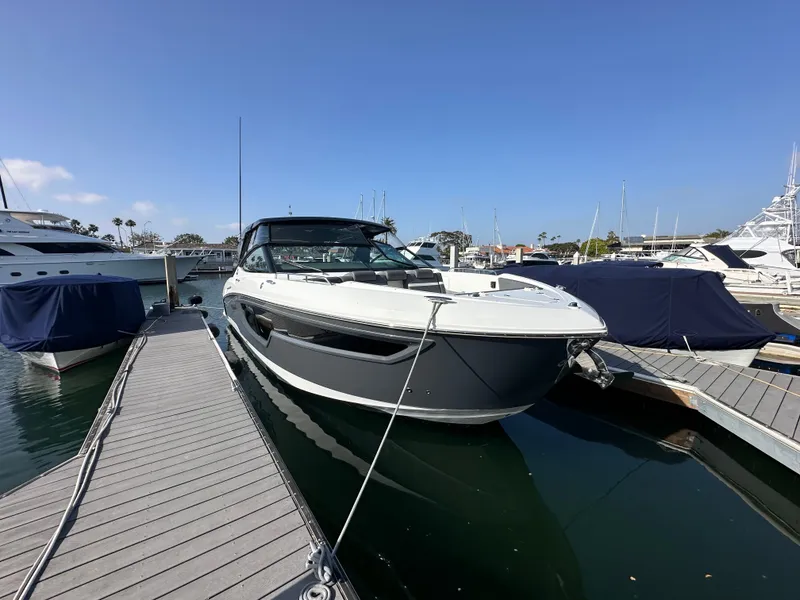 Slide: The Image of A 2021 Cruisers Yachts 38 GLS docked at a marina, surrounded by other boats. - 24