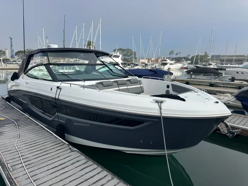 Slide: The Image of A modern 2021 Cruisers Yachts 38 GLS docked at a marina, surrounded by other boats. - 12