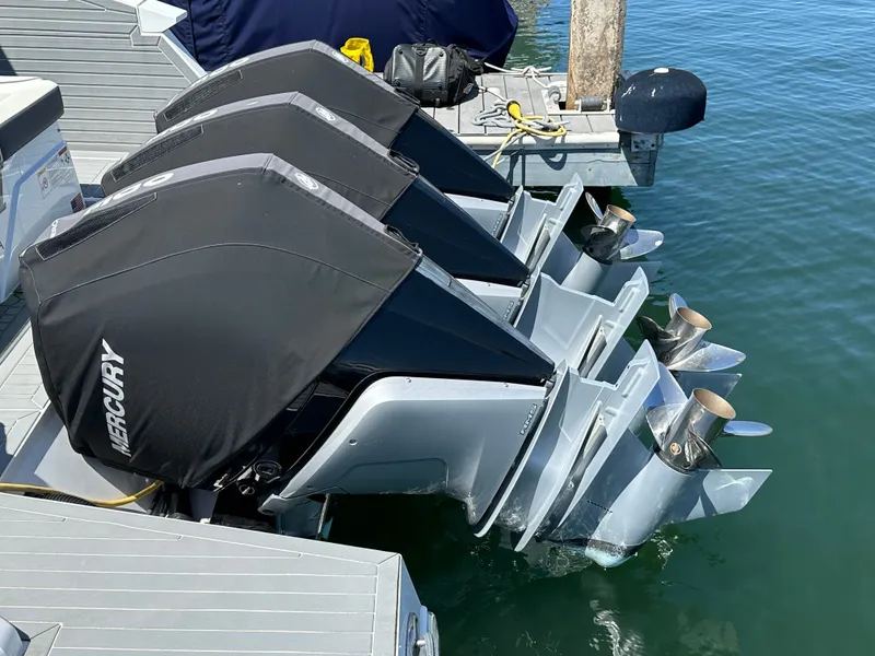 Slide: The Image of Three Mercury outboard engines are mounted on the stern of a boat docked at a pier. - 27