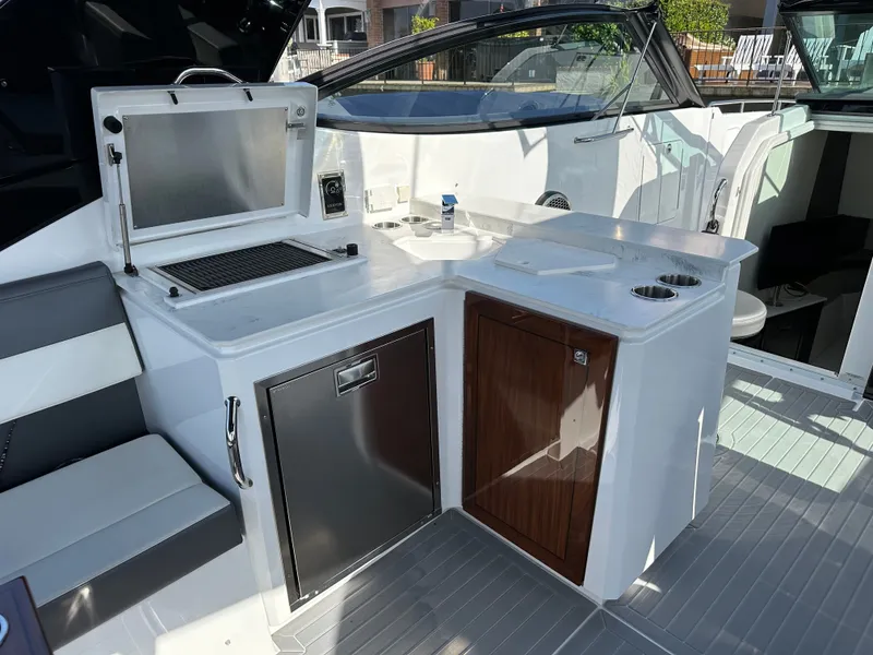 Slide: The Image of The 2021 Cruisers Yachts 38 GLS features an outdoor kitchen with a grill, sink, and storage. - 30