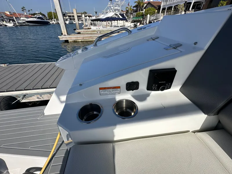 Slide: The Image of The image shows the cockpit of a 2021 Cruisers Yachts 38 GLS. There are cup holders and a control panel. - 46