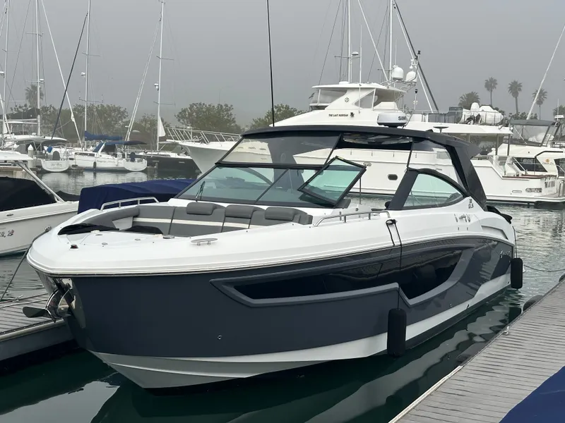 Slide: The Image of A modern 2021 Cruisers Yachts 38 GLS docked in a marina, surrounded by other boats. - 10