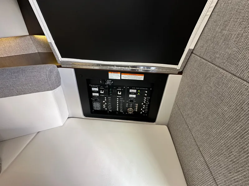 Slide: The Image of The image shows the electrical control panel of a 2021 Cruisers Yachts 38 GLS, set into a cushioned seat. - 40