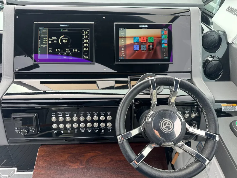 Slide: The Image of The cockpit of the 2021 Cruisers Yachts 38 GLS features two Simrad displays and a sleek steering wheel. - 5