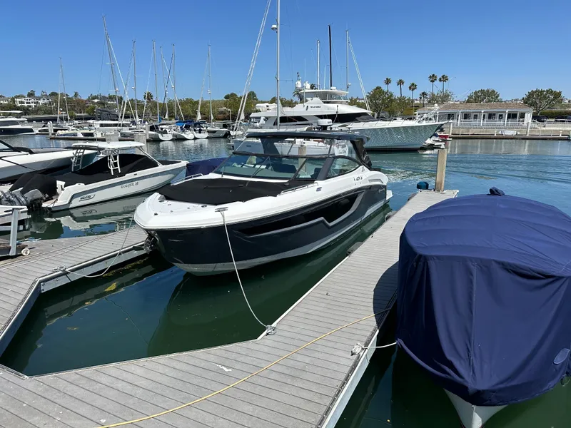 Slide: The Image of A 2021 Cruisers Yachts 38 GLS is docked at a marina, surrounded by other boats. - 23