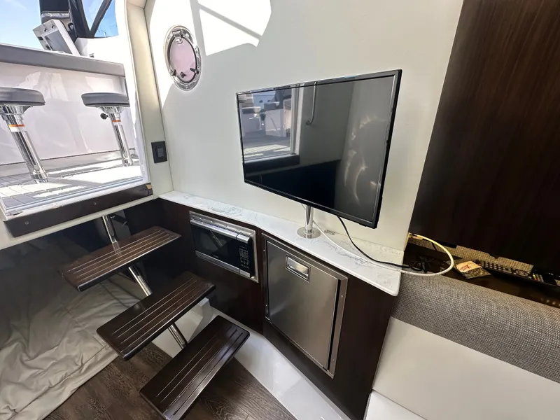 Slide: The Image of Interior of a 2021 Cruisers Yachts 38 GLS with a TV, microwave, and stairs. - 36