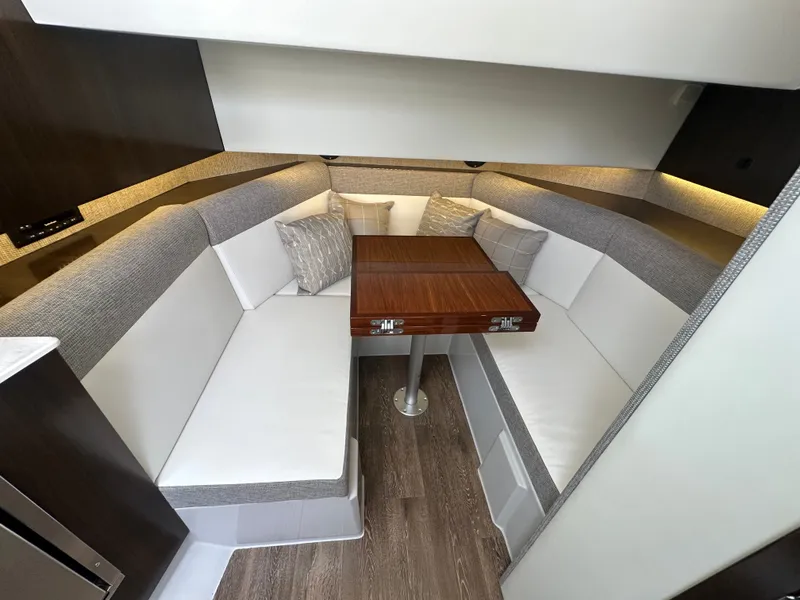 Slide: The Image of The 2021 Cruisers Yachts 38 GLS cabin features a cozy seating area with a wooden table. - 14