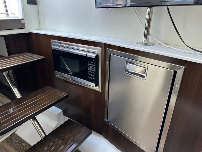 Slide: The Image of The interior view shows a microwave and a refrigerator next to a staircase with wooden steps. - 35