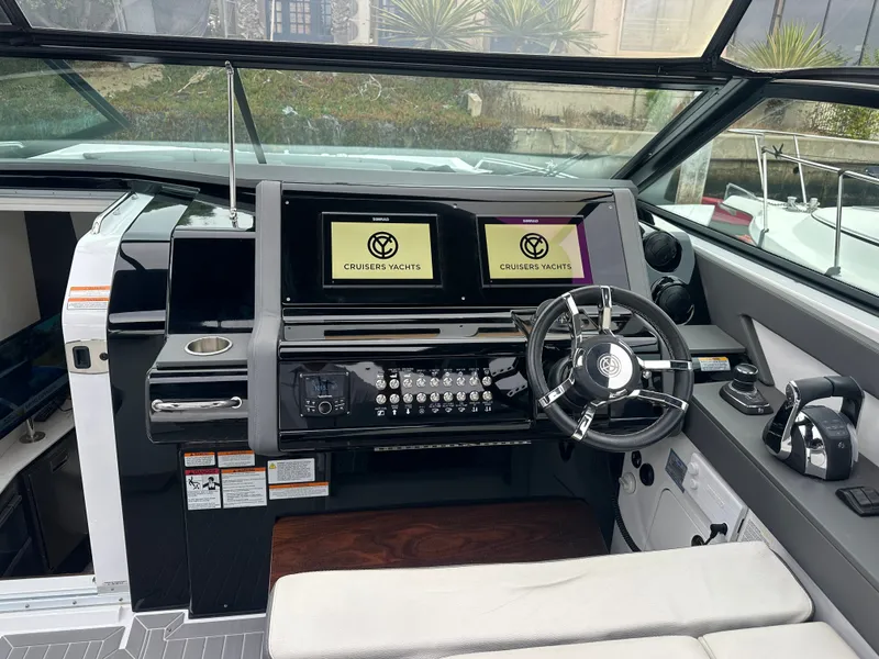 Slide: The Image of The cockpit of the 2021 Cruisers Yachts 38 GLS features a modern dashboard with dual screens. - 21