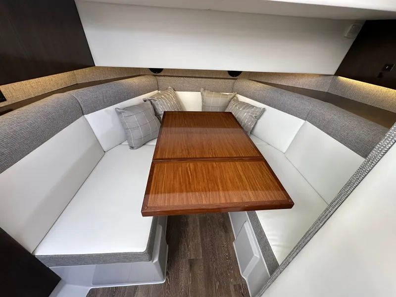 Slide: The Image of Interior of a 2021 Cruisers Yachts 38 GLS with an elegant wooden table and cushioned seating. - 41