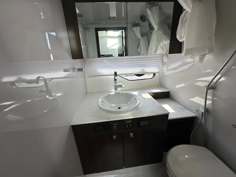 Slide: The Image of The image shows a modern yacht bathroom with a sink, mirror, and toilet. - 39