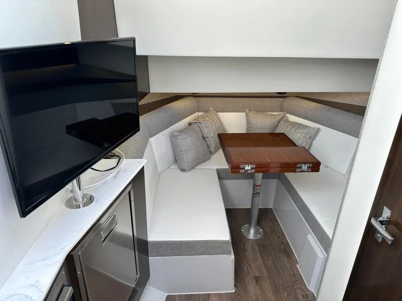Slide: The Image of The 2021 Cruisers Yachts 38 GLS cabin features a cozy seating area with a table and TV. - 34