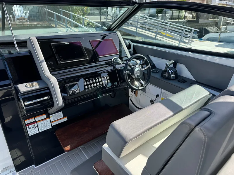 Slide: The Image of The cockpit of the 2021 Cruisers Yachts 38 GLS features a modern dashboard with dual screens and a sleek steering wheel. - 32