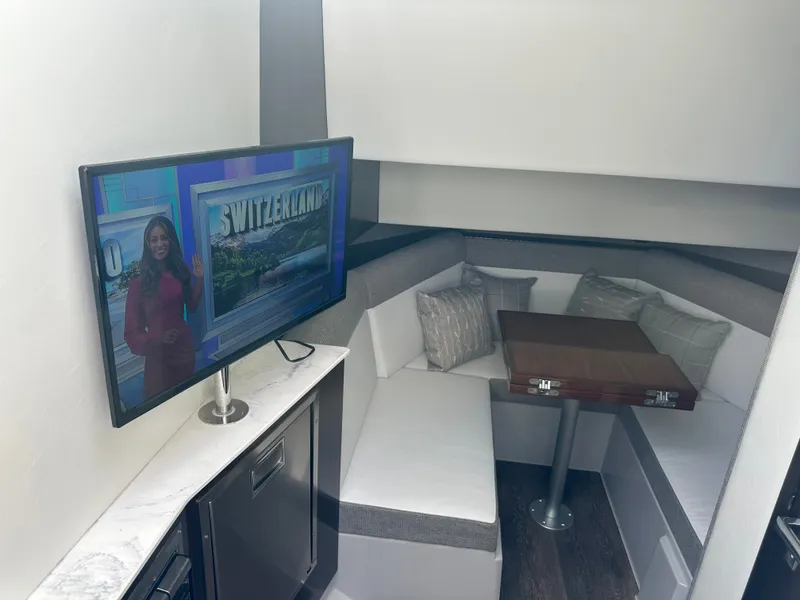 Slide: The Image of Interior of a 2021 Cruisers Yachts 38 GLS with a cozy seating area and a television. - 13