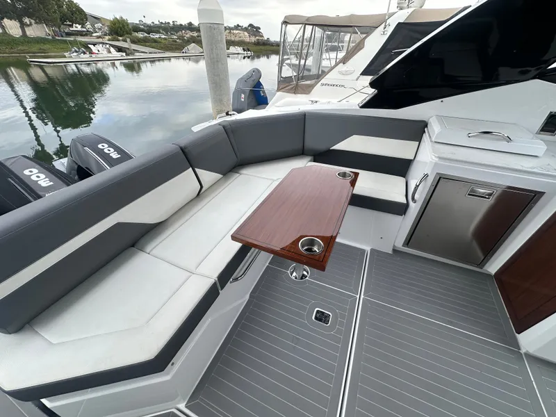 Slide: The Image of The 2021 Cruisers Yachts 38 GLS features an elegant seating area with a wooden table and stainless steel accents. - 25