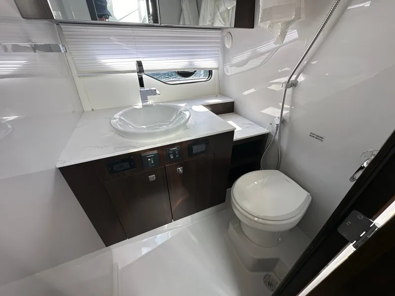 Slide: The Image of The image shows a modern yacht bathroom with a sink, toilet, and shower. - 38