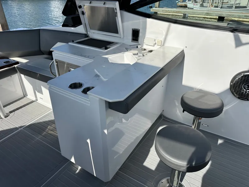 Slide: The Image of The 2021 Cruisers Yachts 38 GLS features a modern outdoor kitchen with bar stools and a grill. - 29