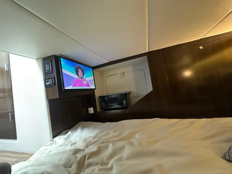 Slide: The Image of Interior of a 2021 Cruisers Yachts 38 GLS with a TV above a bed. - 15