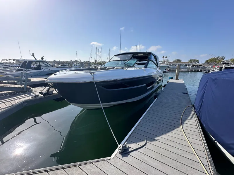 Slide: The Image of A 2021 Cruisers Yachts 38 GLS docked at a sunny marina, surrounded by calm waters. - 19