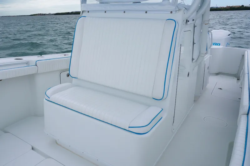 Slide: The Image of 2011 Yellowfin 32 Offshore boat interior with white seating and blue trim on the water. - 10