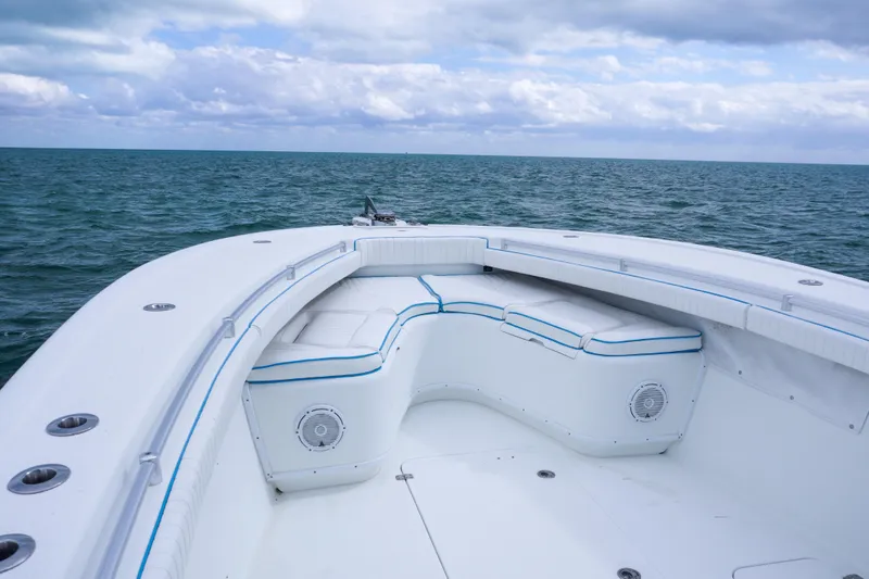 Slide: The Image of 2011 Yellowfin 32 Offshore boat interior with ocean view, featuring cushioned seating. - 11