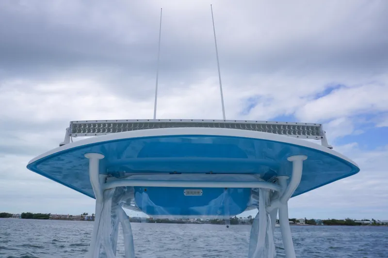 Slide: The Image of 2011 Yellowfin 32 Offshore boat with blue T-top and antennas on water. - 16