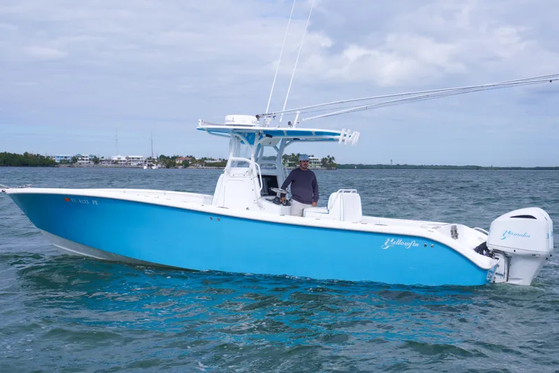 Slide: The Image of 2011 Yellowfin 32 Offshore boat on water, featuring a vibrant blue hull. - 4