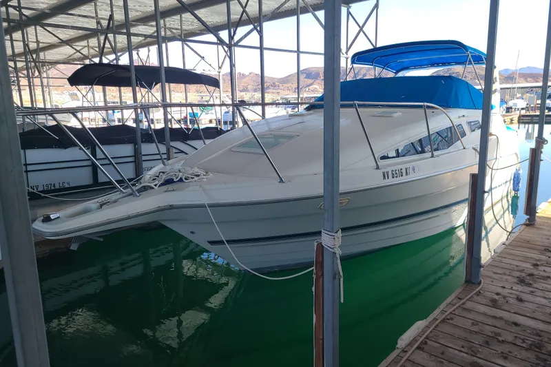The Image of 1998 Bayliner 2855 Ciera Sunbridge docked in a marina with blue canopy. - 0