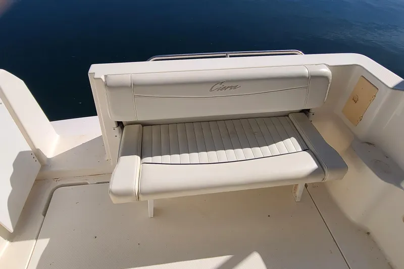Slide: The Image of 1998 Bayliner 2855 Ciera Sunbridge boat seat with white upholstery, docked on calm water. - 15