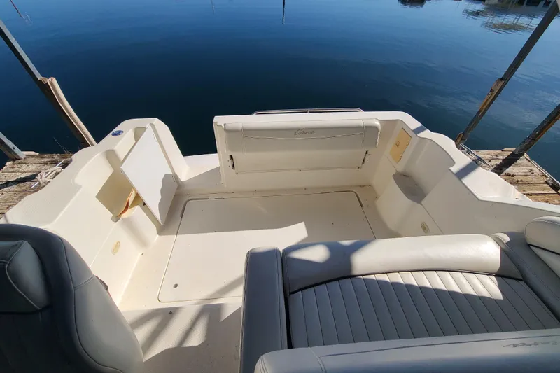 Slide: The Image of 1998 Bayliner 2855 Ciera Sunbridge boat interior with seating, docked by calm water. - 16