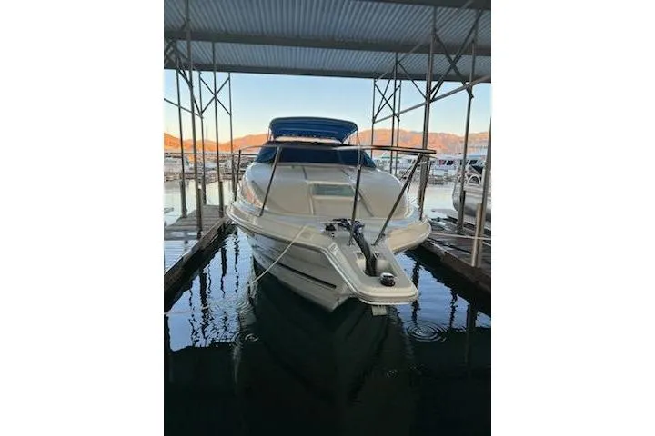 Slide: The Image of 1998 Bayliner 2855 Ciera Sunbridge docked in a marina under a metal canopy. - 3