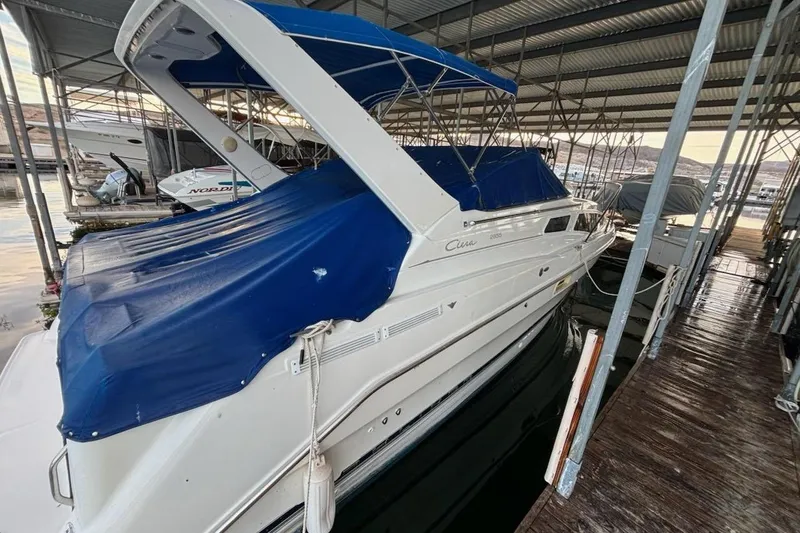 Slide: The Image of 1998 Bayliner 2855 Ciera Sunbridge with blue canopy docked in marina. - 5