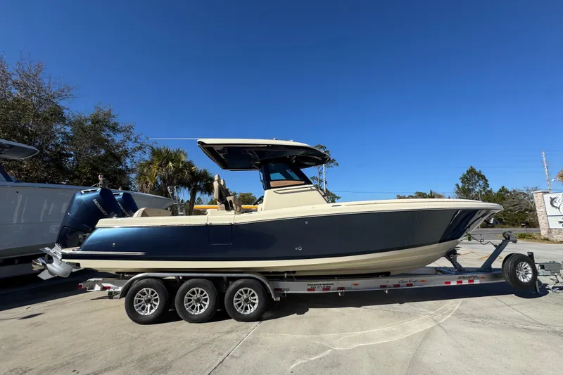 Slide: The Image of 2026 Chris-Craft Catalina 31 boat on trailer, parked outdoors under clear blue sky. - 11