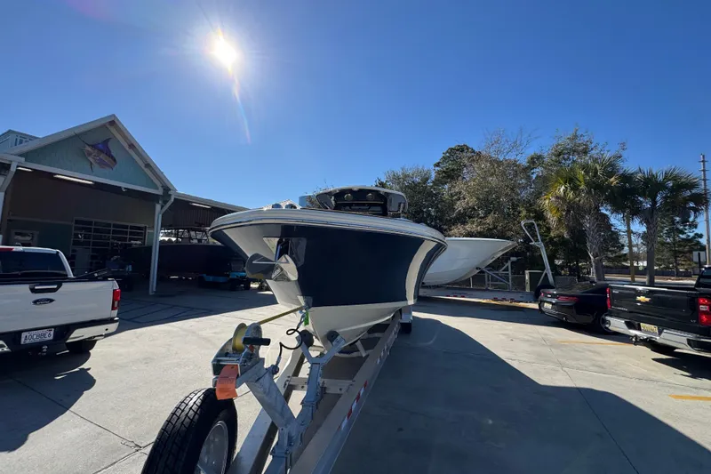 Slide: The Image of 2026 Chris-Craft Catalina 31 boat on trailer under bright sun, parked near trucks. - 6