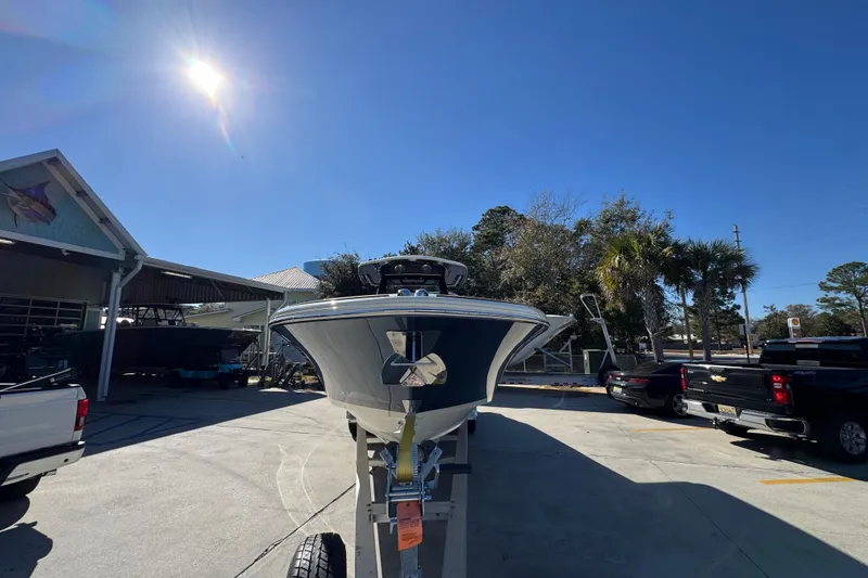 Slide: The Image of 2026 Chris-Craft Catalina 31 boat on trailer under bright sun at dealership. - 7